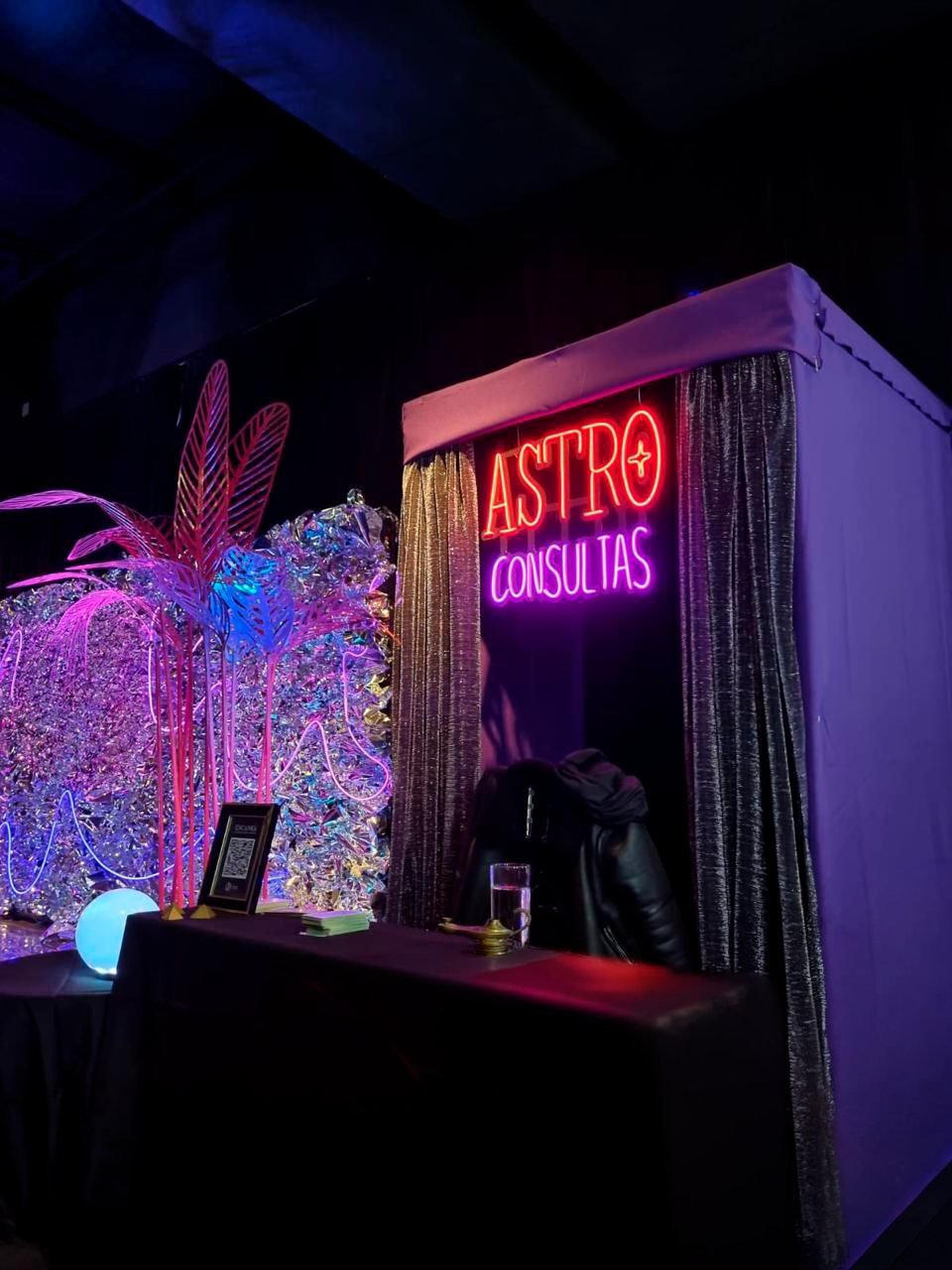 La carpa de AstroConsultas armada en un salón de fiestas, con su cartel de neón encendido
