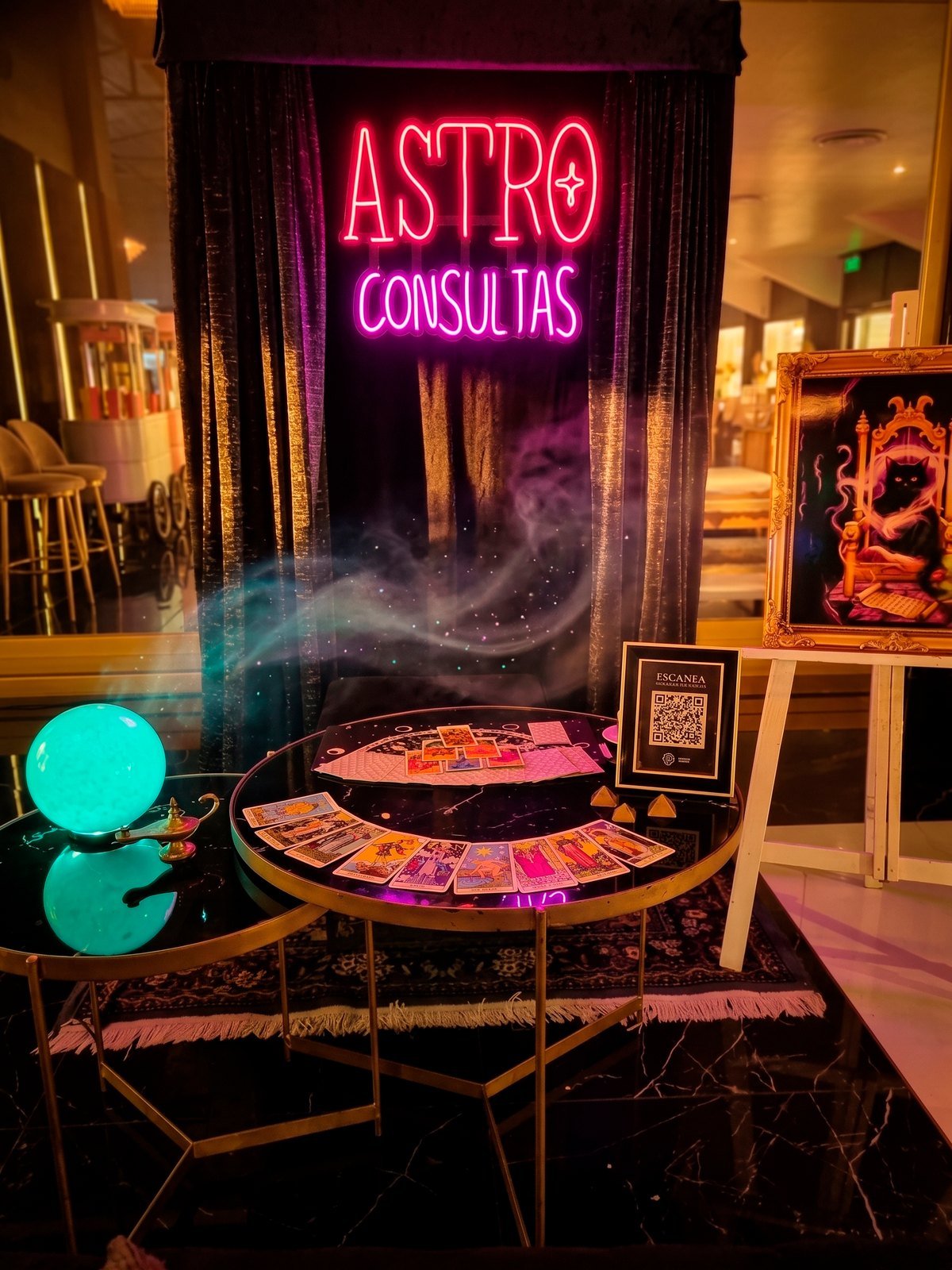 La carpa de tarot montada en un evento, con su cartel de neón encendido